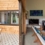 Interior de casa moderna en el sur de Chile con estufa a pellet, mobiliario de madera y ventanales hacia la naturaleza