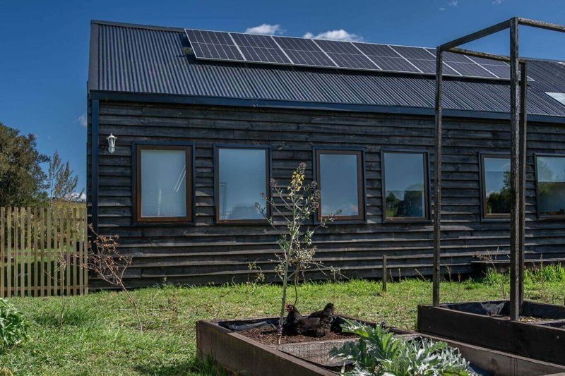 Paneles solares y sistema de recolección de agua lluvia en casa del sur de Chile