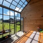 Galería acristalada orientada al sol en casa sustentable diseñada por Estudio Nalca en el sur de Chile.