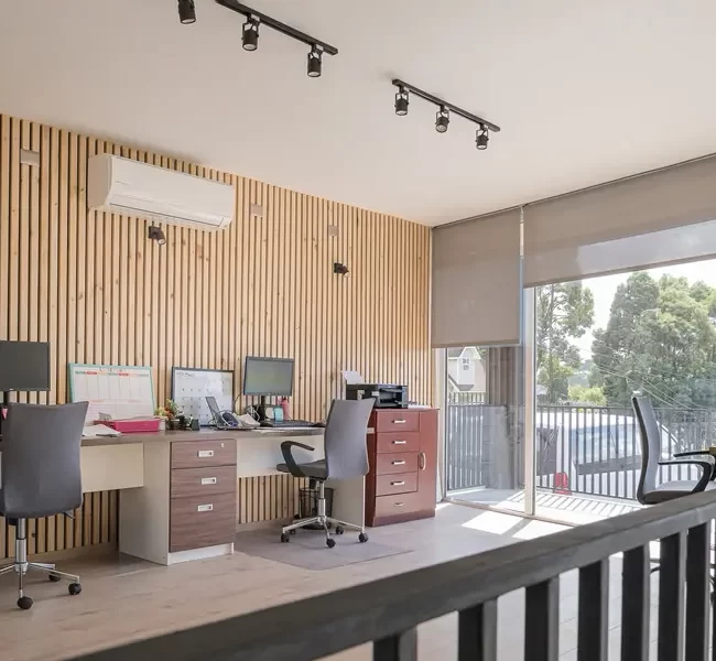 Interior de oficina con colores claros y madera, creando un espacio de trabajo cálido y funcional en Puerto Varas.