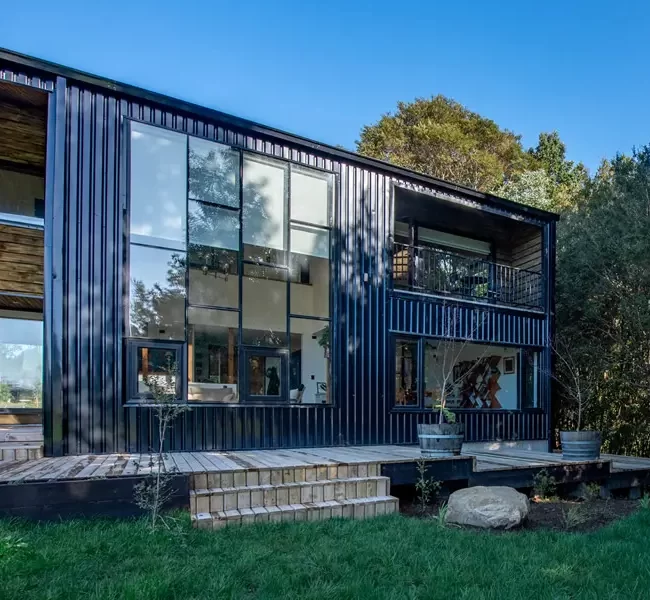 Terraza exterior de la Casa II. Diseño de líneas modernas con el uso de madera, que se integra al jardín y la parcela.
