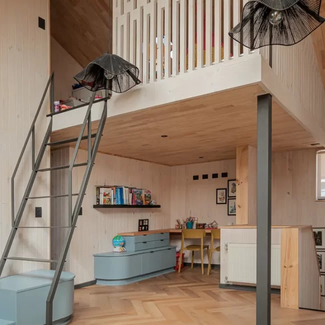 Solución arquitectónica de altillo funcional en dormitorio infantil para aprovechar el entretecho y altura de la casa.