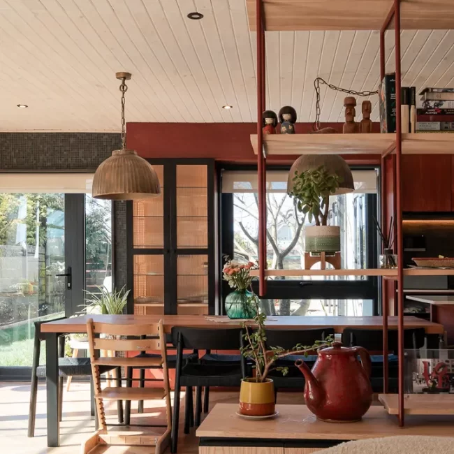 Diseño de interior con doble altura, vigas a la vista y optimización de luz natural en vivienda renovada en Puerto Varas.