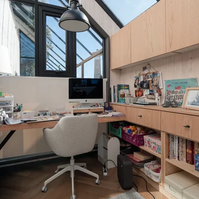 Espacio de home office diseñado a medida bajo ventanal para aprovechar la luz natural y vistas al entorno.