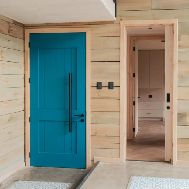 Acceso de Casa DLM con puerta azul, madera y diseño arquitectónico en el sur de Chile